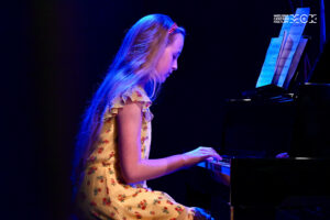 Nastoletnia dziewczynka gra na fortepianie.