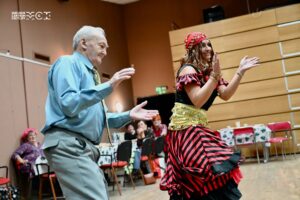 Kobieta przebrana za Cygankę i starszy mężczyzna tańczą obok siebie