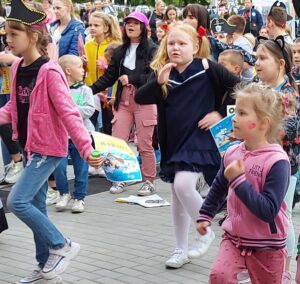 Grupa dzieci tańczyprzed sceną.