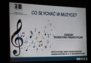 Ekran, na którym z projektora rzucony jest napis: "Co słychać w muzyce?" koncert terapeutyczno-edukacyjny