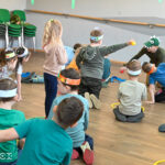 Zdjęcie przedstawia grupę dzieci bawiących się z instruktorami.