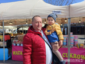 Tata z synem przy stoisku ze słodkościami